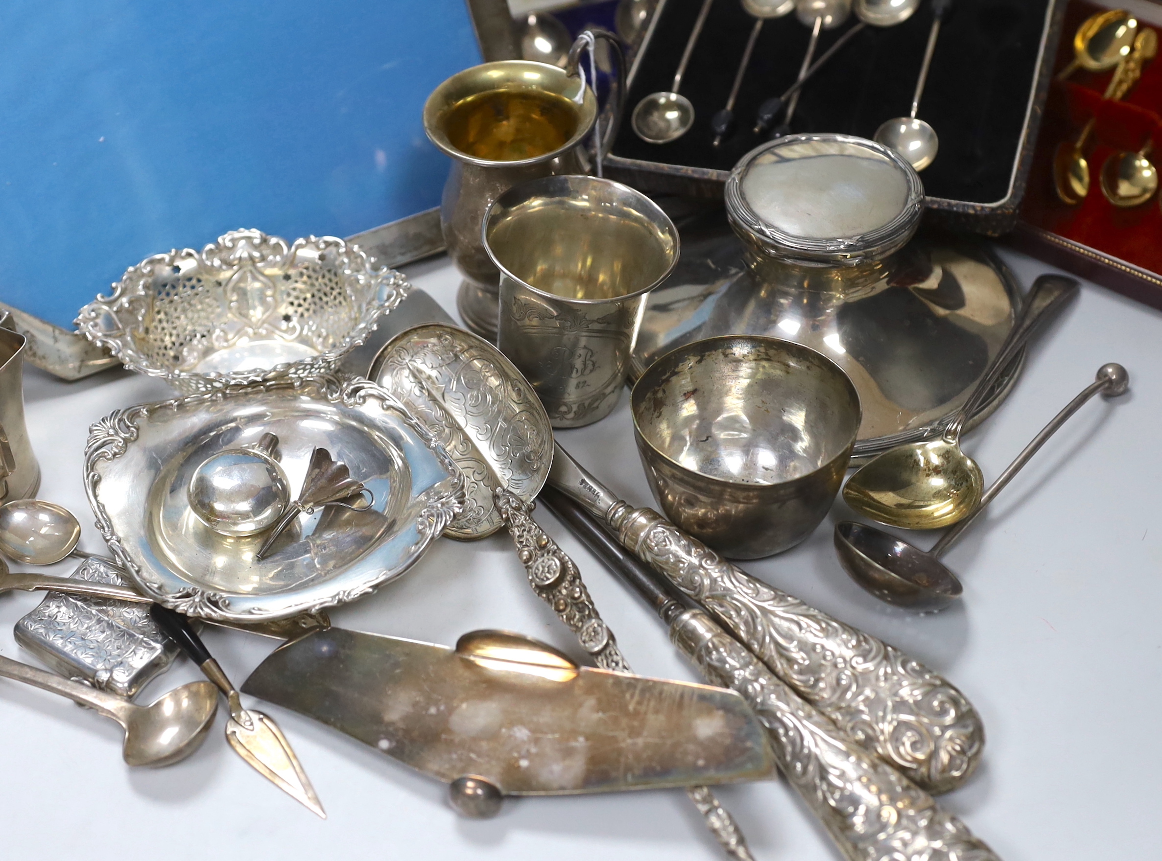Assorted silver and white metal items including capstan inkwell, mug, photograph frame, cased and loose flatware, anointing spoon replica, beakers etc.